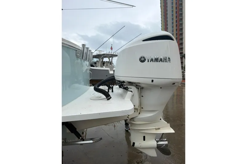 Slide: The Image of 2018 Regulator 31 boat with Yamaha outboard motor, docked on a rainy day. - 32