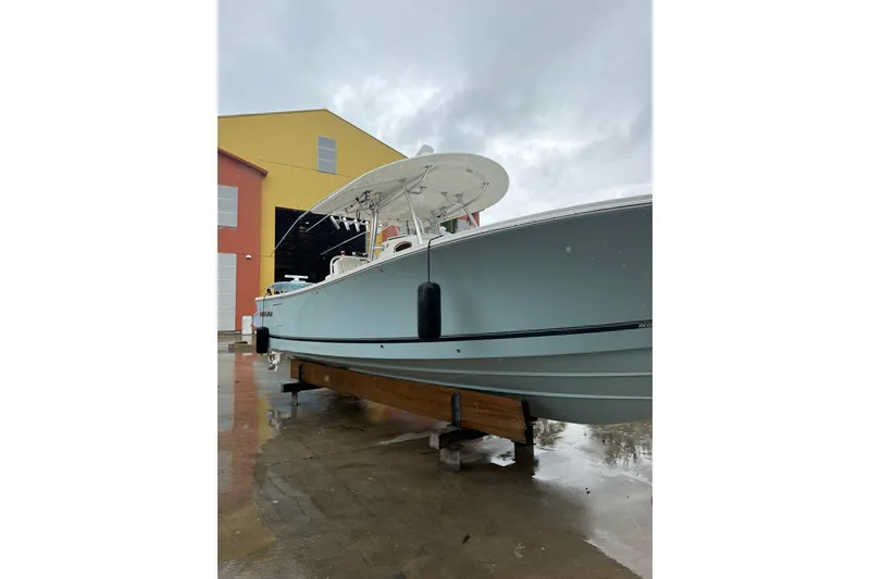 Slide: The Image of 2018 Regulator 31 boat on display outside a colorful building on a rainy day. - 4