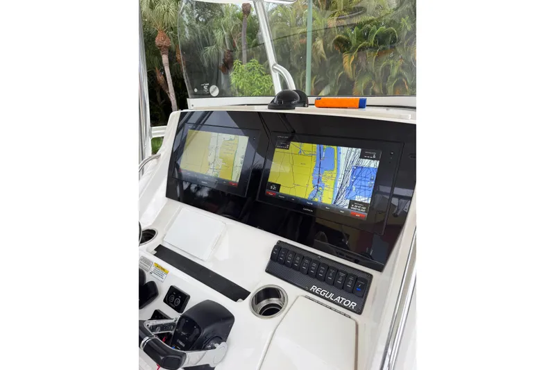 Slide: The Image of 2018 Regulator 31 boat dashboard with dual navigation screens and control panel. - 7