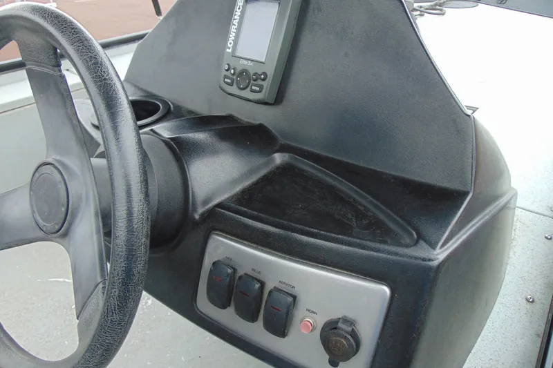 Slide: The Image of 2016 Crestliner 1600 Storm Poly dashboard with steering wheel and control panel. - 11
