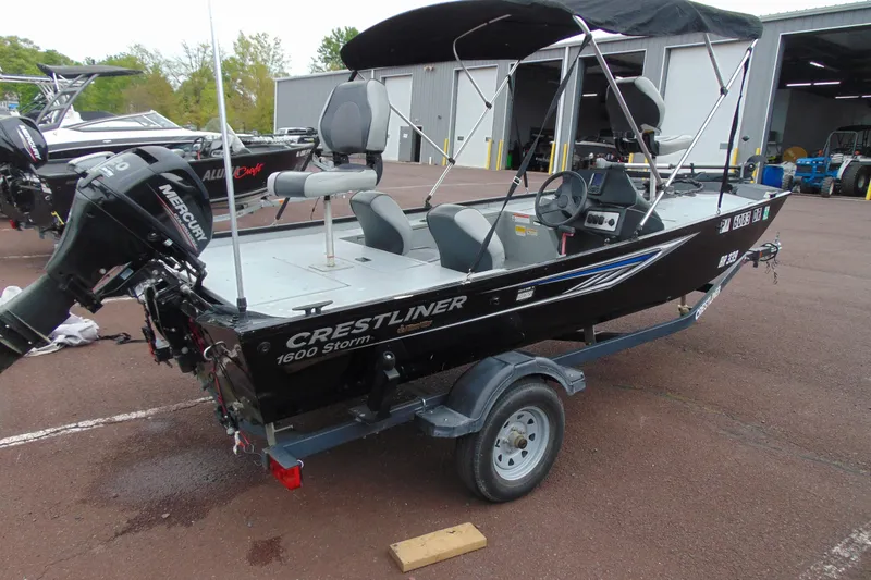 Slide: The Image of 2016 Crestliner 1600 Storm Poly fishing boat on trailer, featuring Mercury outboard motor. - 4