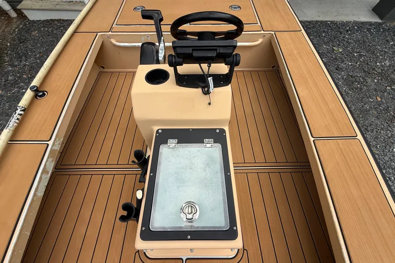 Slide: The Image of 2018 Cast and Blast 17CC boat interior with steering console and wooden deck. - 17