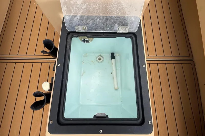 Slide: The Image of Livewell on 2018 Cast and Blast 17CC boat with rod holders and teak flooring. - 18