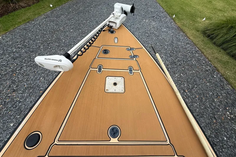 Slide: The Image of 2018 Cast and Blast 17CC boat deck with Minn Kota trolling motor on gravel path. - 19