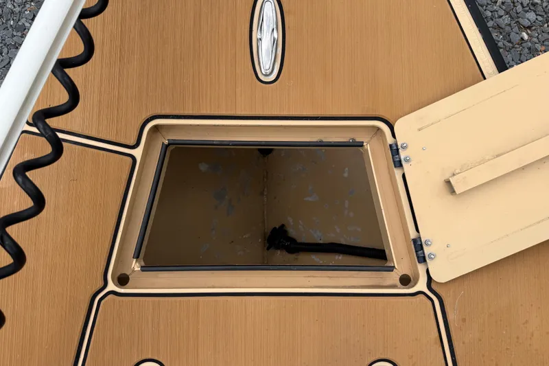 Slide: The Image of Open hatch on 2018 Cast and Blast 17CC boat deck, showcasing storage compartment. - 20