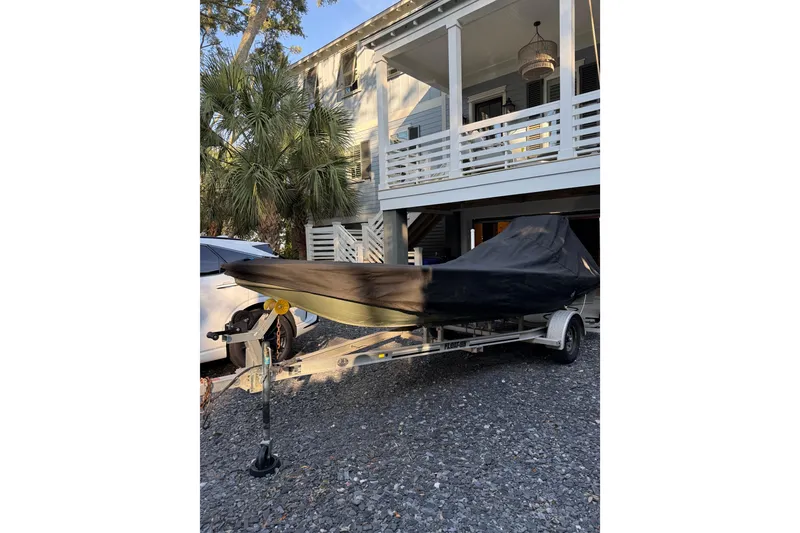 Slide: The Image of 2018 Cast and Blast 17CC boat covered on trailer, parked outside a house. - 24