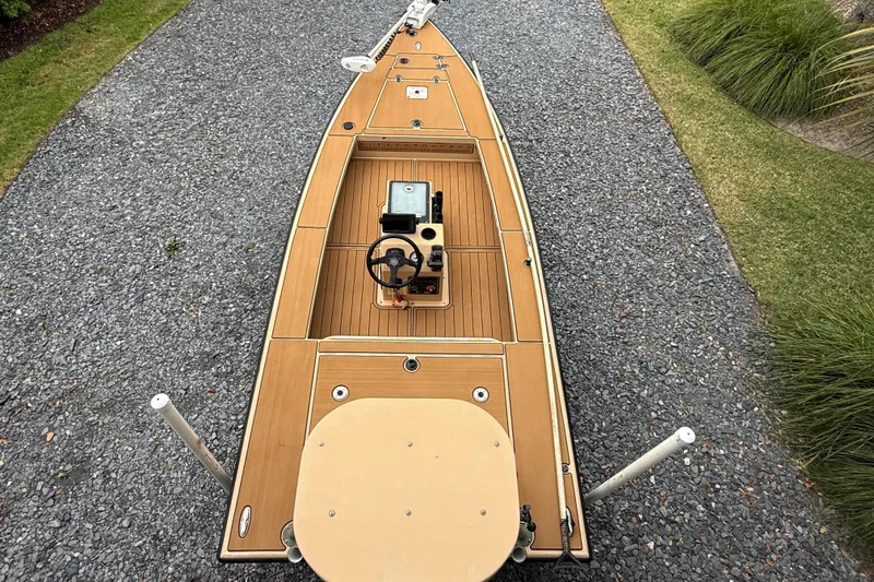 Slide: The Image of 2018 Cast and Blast 17CC boat on gravel path, featuring wooden deck and steering console. - 4