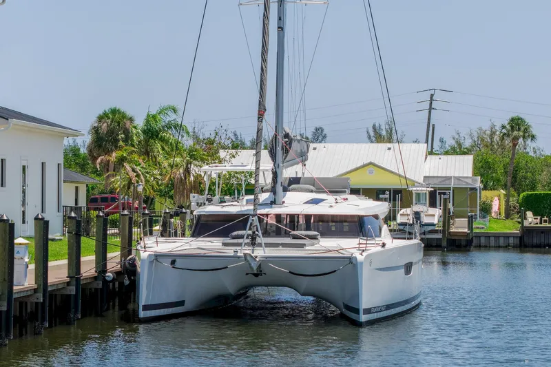 Slide: The Image of 2020 Fountaine Pajot Saona 47 catamaran docked in a scenic canal setting. - 10