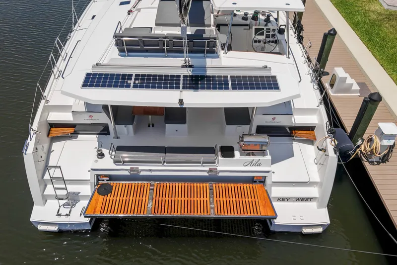 Slide: The Image of 2020 Fountaine Pajot Saona 47 catamaran docked, featuring solar panels and spacious deck. - 13