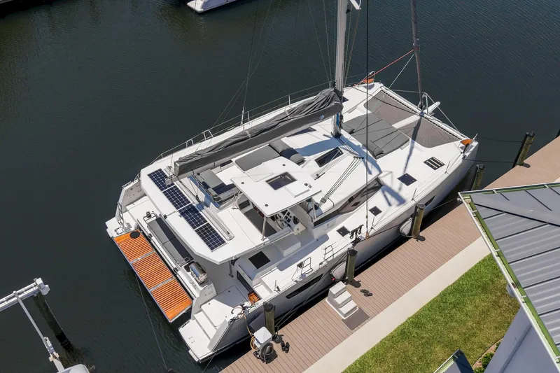 Slide: The Image of 2020 Fountaine Pajot Saona 47 catamaran docked, featuring solar panels and spacious deck. - 14