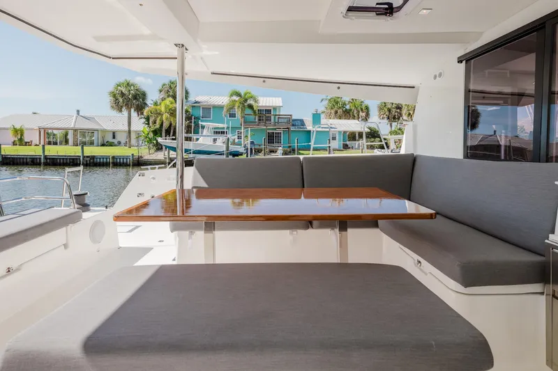 Slide: The Image of Spacious seating area on 2020 Fountaine Pajot Saona 47 catamaran, featuring a sleek wooden table. - 16