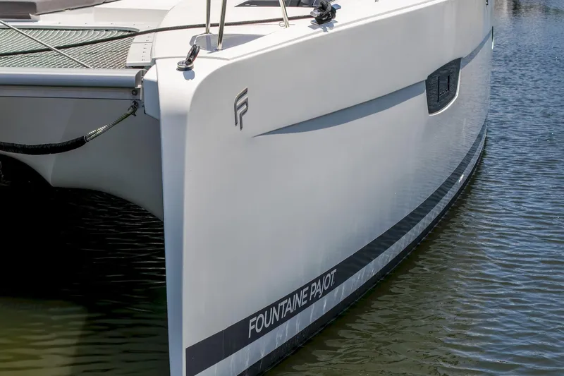 Slide: The Image of 2020 Fountaine Pajot Saona 47 catamaran on water, showcasing sleek design and branding. - 17
