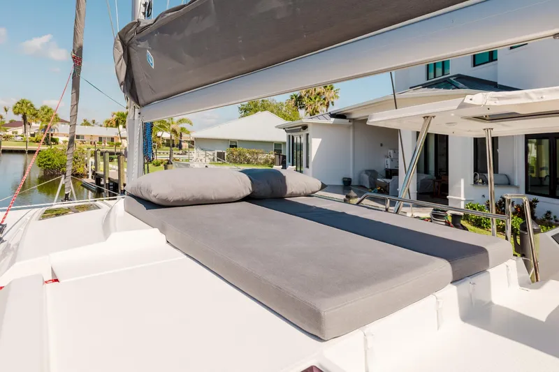 Slide: The Image of 2020 Fountaine Pajot Saona 47 catamaran with sunbathing cushions on deck, docked near waterfront homes. - 30
