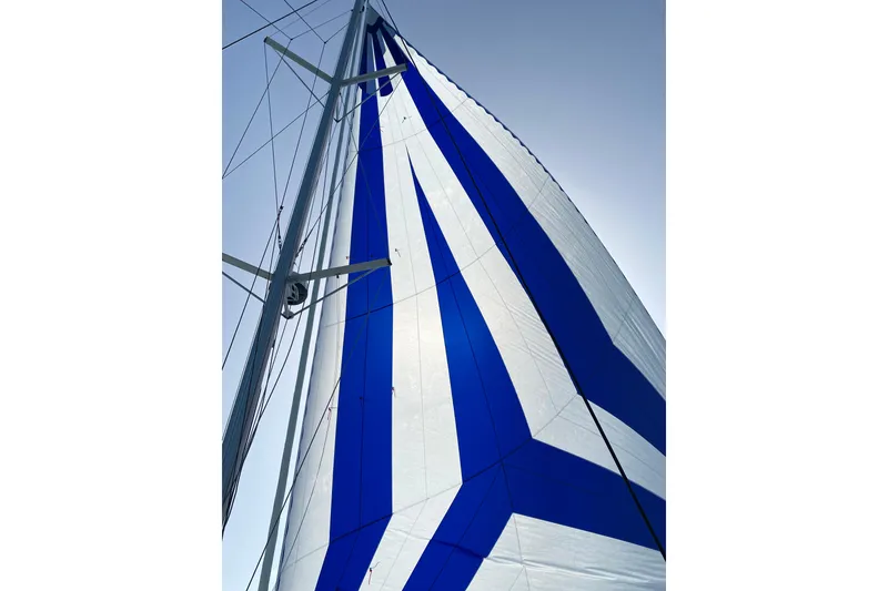 Slide: The Image of Sail of 2020 Fountaine Pajot Saona 47 catamaran with blue and white design against clear sky. - 74