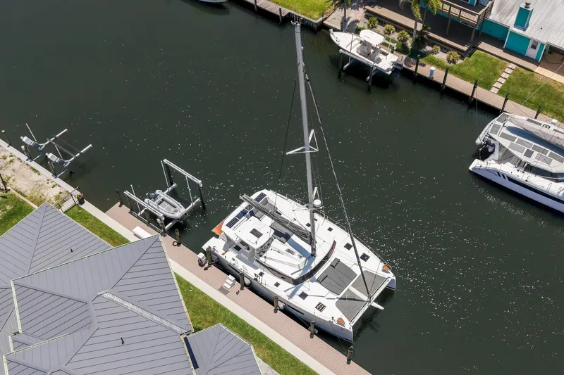 Slide: The Image of Aerial view of 2020 Fountaine Pajot Saona 47 catamaran docked in a serene canal. - 9