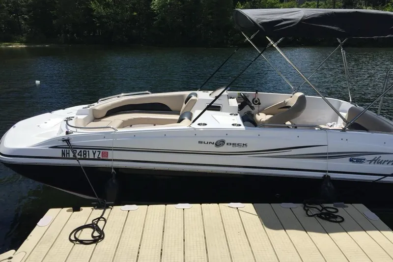 Slide: The Image of 2014 Hurricane SunDeck Sport 188 OB boat docked on a serene lake. - 2