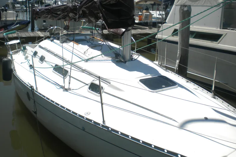The Image of 1994 Beneteau First 310 sailboat docked at marina, featuring sleek white design. - 0