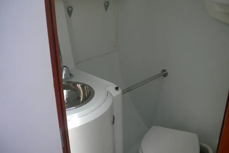 Slide: The Image of Compact bathroom in a 1994 Beneteau First 310 sailboat, featuring a sink and toilet. - 10