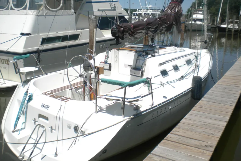 Slide: The Image of 1994 Beneteau First 310 sailboat docked at a marina, showcasing sleek design. - 3