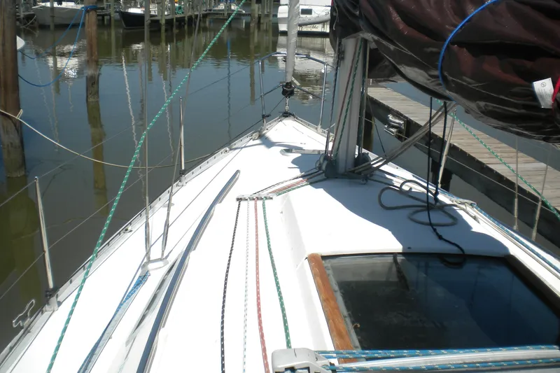 Slide: The Image of 1994 Beneteau First 310 sailboat docked, showcasing deck and rigging details. - 4