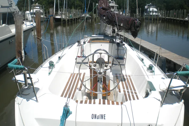 Slide: The Image of 1994 Beneteau First 310 sailboat docked at marina, featuring spacious cockpit and steering wheel. - 7