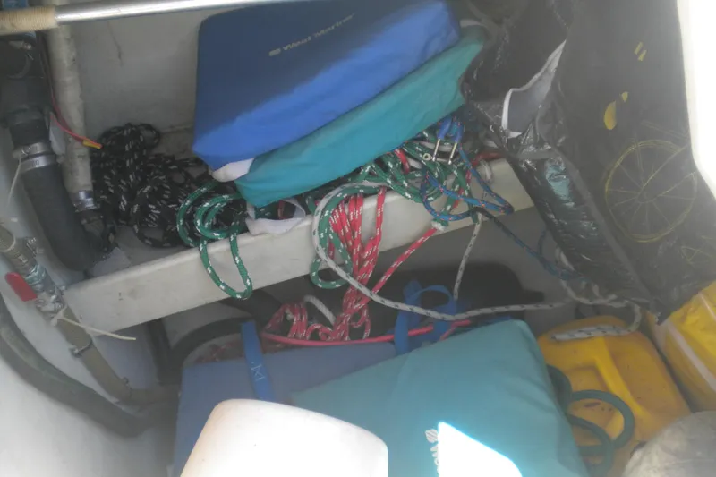 Slide: The Image of Storage area of a 1994 Beneteau First 310 sailboat with ropes and cushions. - 9