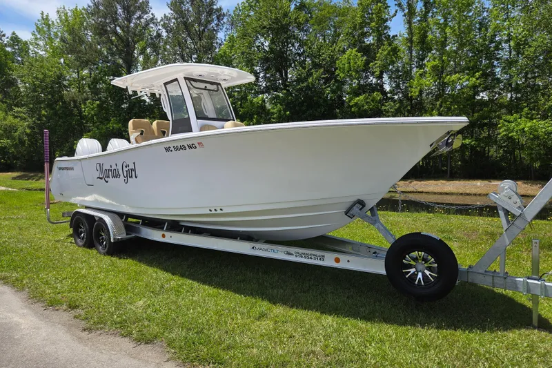 Slide: The Image of 2025 Sportsman Open 262 Center Console boat on trailer, parked on grass. - 1