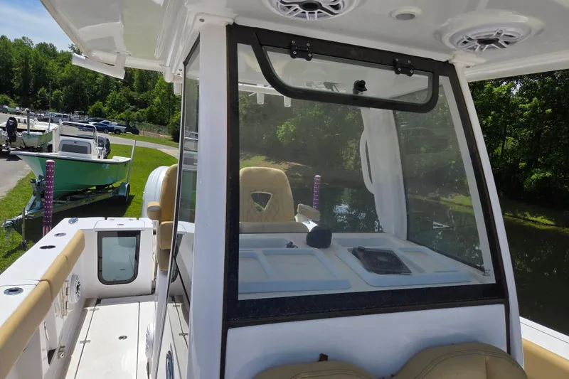 Slide: The Image of 2025 Sportsman Open 262 Center Console boat docked near lush greenery. - 14