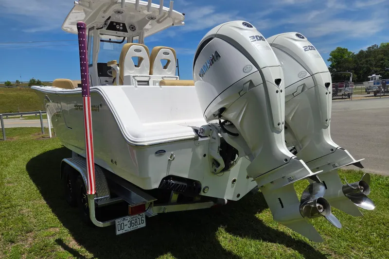 Slide: The Image of 2025 Sportsman Open 262 Center Console boat with dual outboard engines on a trailer. - 4