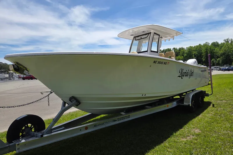 Slide: The Image of 2025 Sportsman Open 262 Center Console boat on trailer, parked on grass under blue sky. - 7