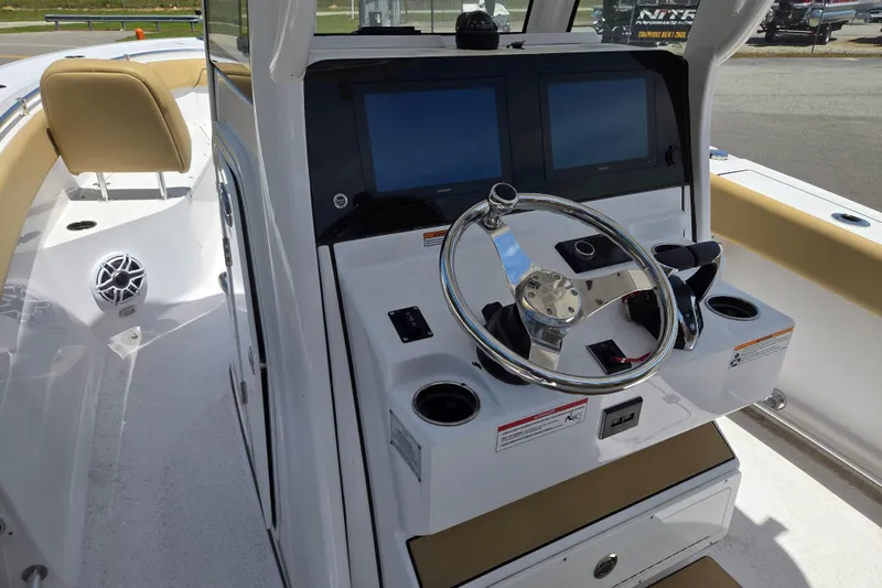 Slide: The Image of 2025 Sportsman Open 262 Center Console boat helm with dual screens and steering wheel. - 9