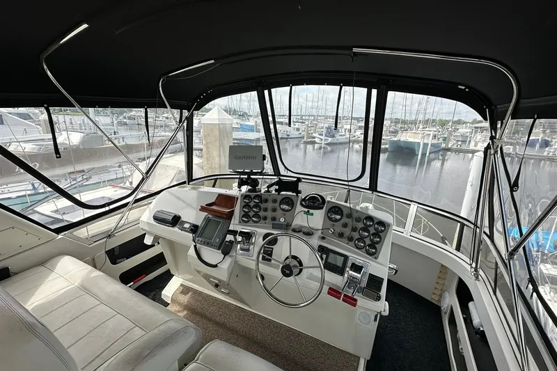 Slide: The Image of 1997 Carver 355 Aft Cabin Motor Yacht helm with marina view, featuring Garmin navigation. - 12
