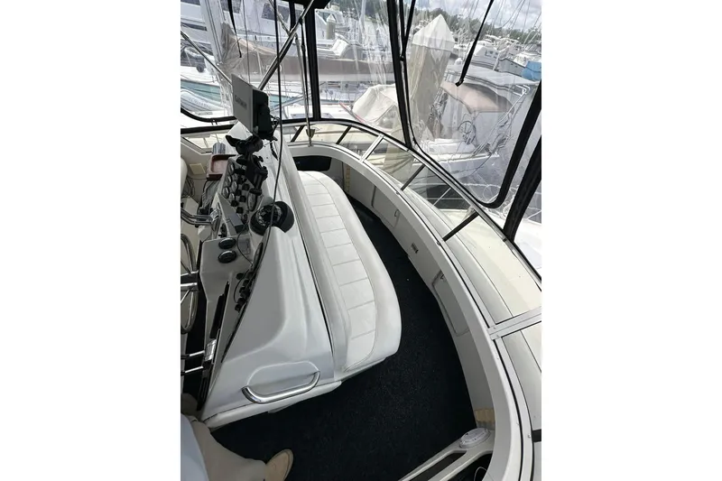 Slide: The Image of 1997 Carver 355 Aft Cabin Motor Yacht helm with seating and navigation controls. - 18
