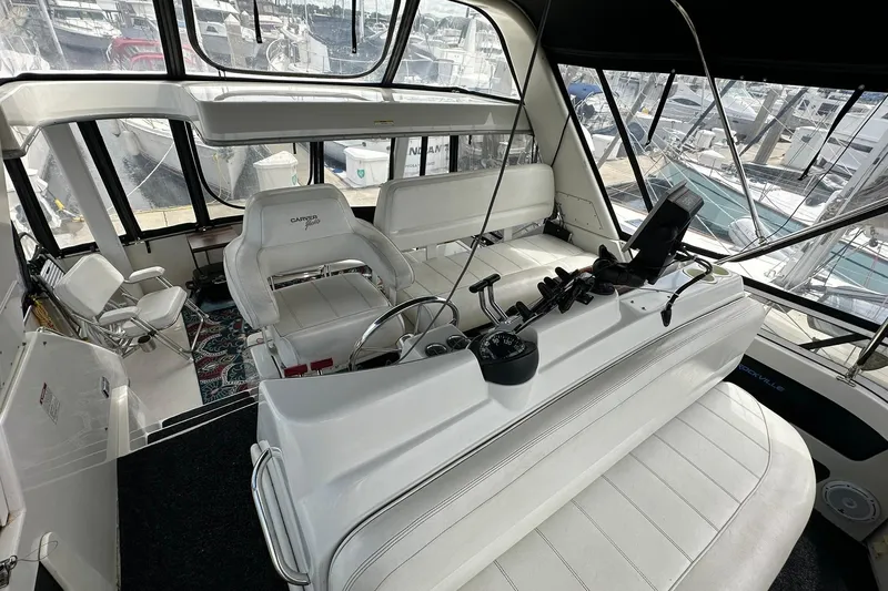 Slide: The Image of Interior view of 1997 Carver 355 Aft Cabin Motor Yacht helm with white seating and controls. - 19