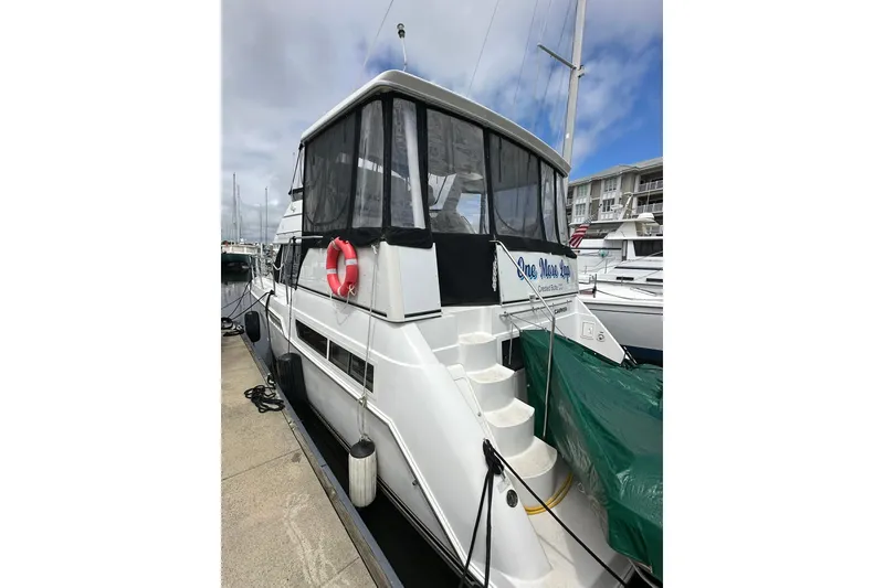 Slide: The Image of 1997 Carver 355 Aft Cabin Motor Yacht docked at marina, featuring aft deck and stairs. - 2