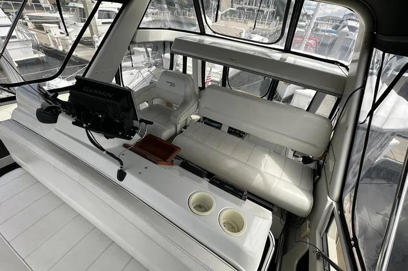 Slide: The Image of 1997 Carver 355 Aft Cabin Motor Yacht helm with Garmin navigation system and white seating. - 20