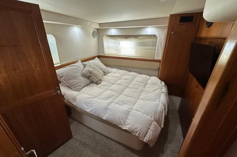 Slide: The Image of Cozy bedroom in 1997 Carver 355 Aft Cabin Motor Yacht with plush bedding and wooden accents. - 28