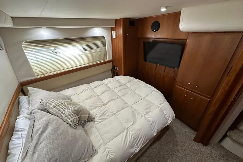 Slide: The Image of Cozy bedroom in 1997 Carver 355 Aft Cabin Motor Yacht with wood cabinetry and TV. - 31