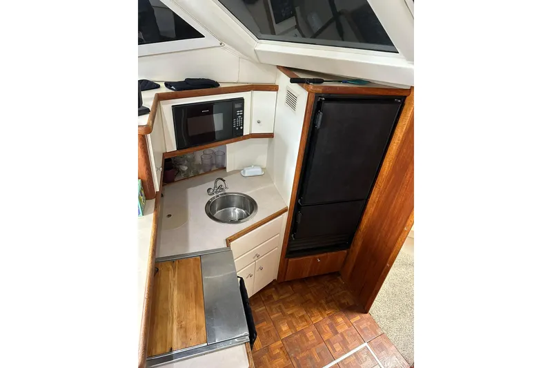 Slide: The Image of 1997 Carver 355 Aft Cabin Motor Yacht kitchen with microwave, sink, and refrigerator. - 34