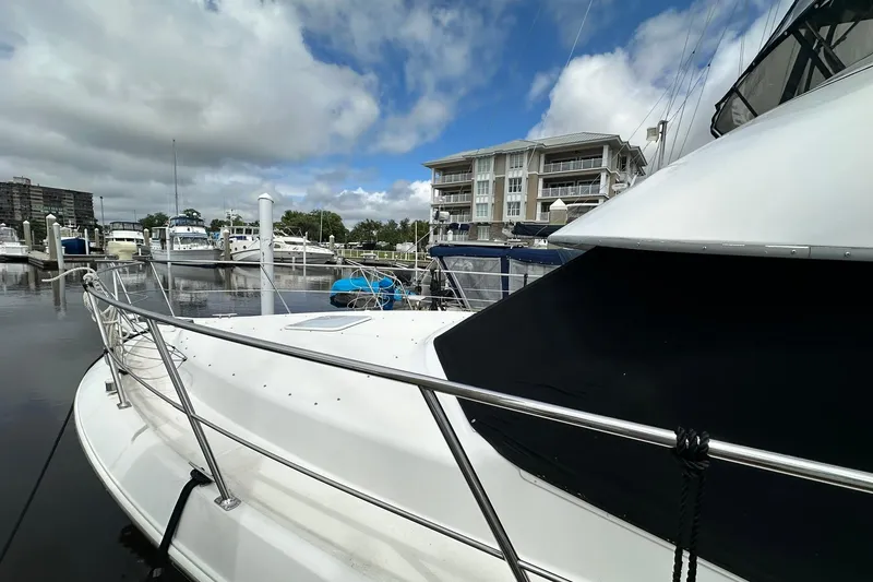 Slide: The Image of 1997 Carver 355 Aft Cabin Motor Yacht docked at marina with buildings in background. - 4
