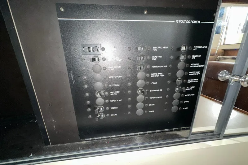 Slide: The Image of Control panel of a 1997 Carver 355 Aft Cabin Motor Yacht, featuring 12-volt DC power switches. - 47