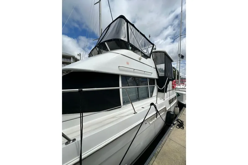 Slide: The Image of 1997 Carver 355 Aft Cabin Motor Yacht docked at marina under cloudy sky. - 5