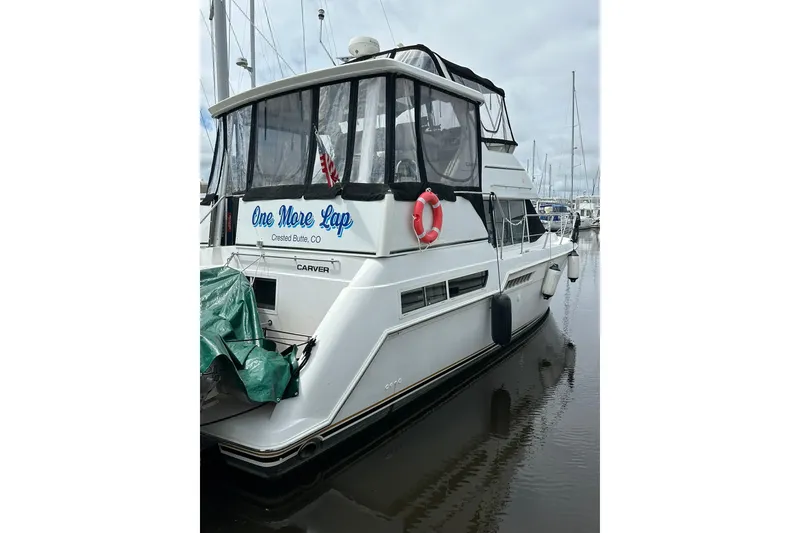 Slide: The Image of 1997 Carver 355 Aft Cabin Motor Yacht docked, featuring "One More Lap" signage. - 6