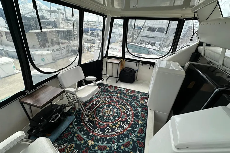 Slide: The Image of 1997 Carver 355 Aft Cabin Motor Yacht interior with chairs, table, and decorative rug. - 9