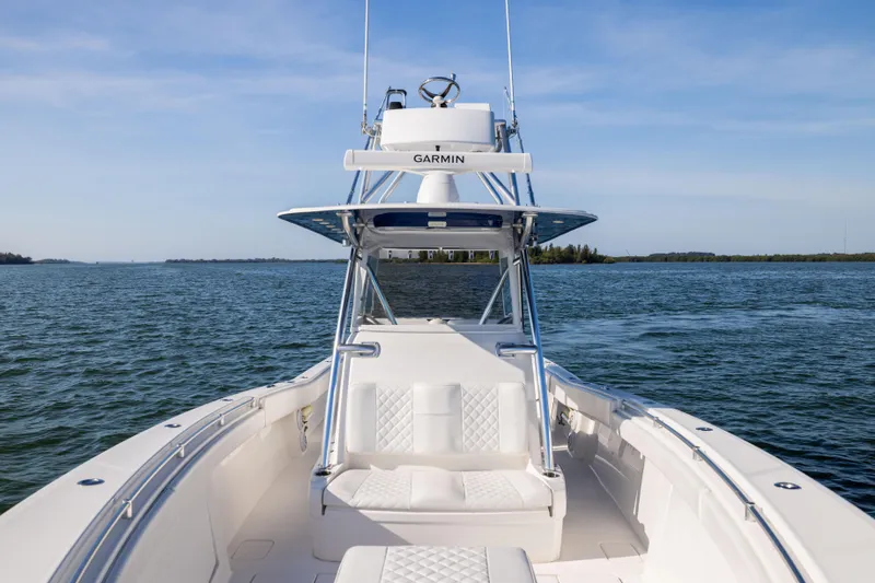 Slide: The Image of 2015 Invincible 39 Open Fisherman boat on calm waters, featuring Garmin equipment. - 18