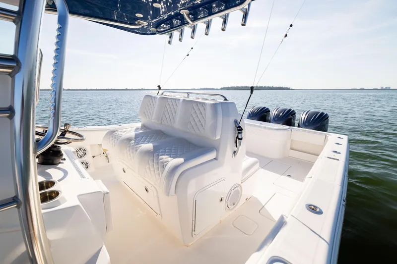 Slide: The Image of 2015 Invincible 39 Open Fisherman boat interior with triple engines on calm water. - 25