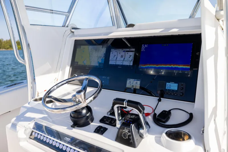 Slide: The Image of Control panel of 2015 Invincible 39 Open Fisherman boat with navigation screens and steering wheel. - 27