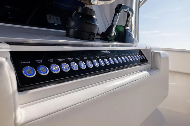 Slide: The Image of Control panel of a 2015 Invincible 39 Open Fisherman boat with illuminated switches. - 28