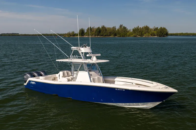 Slide: The Image of 2015 Invincible 39 Open Fisherman boat on calm water, featuring a sleek blue hull. - 3
