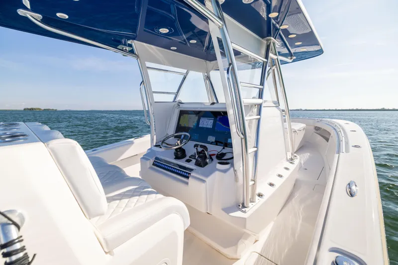 Slide: The Image of 2015 Invincible 39 Open Fisherman boat interior with helm, ocean view, and blue canopy. - 30